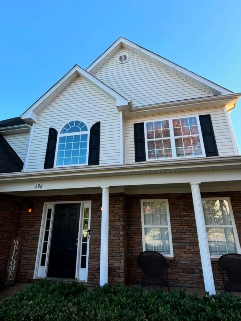 A white house with black shutters and a black door